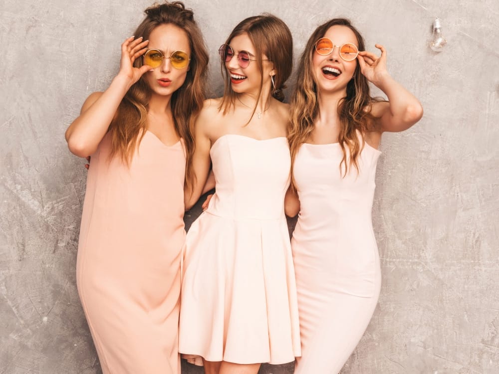 three young beautiful smiling girls trendy summer light pink dresses sexy carefree women posing positive models round sunglasses having fun